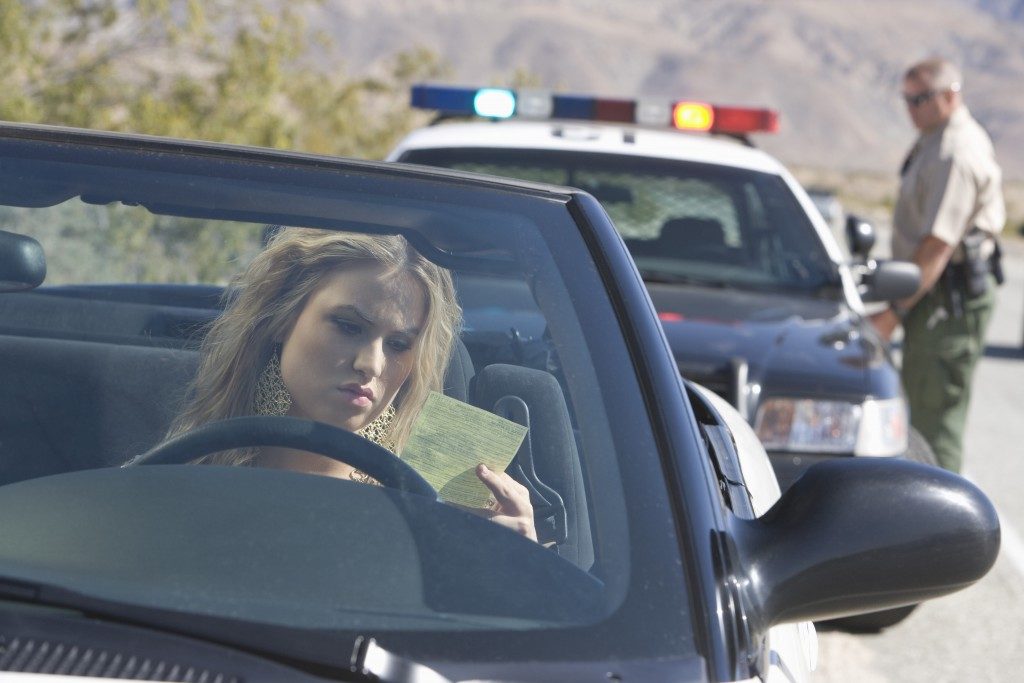 driving girl got a speeding icket from a policeman