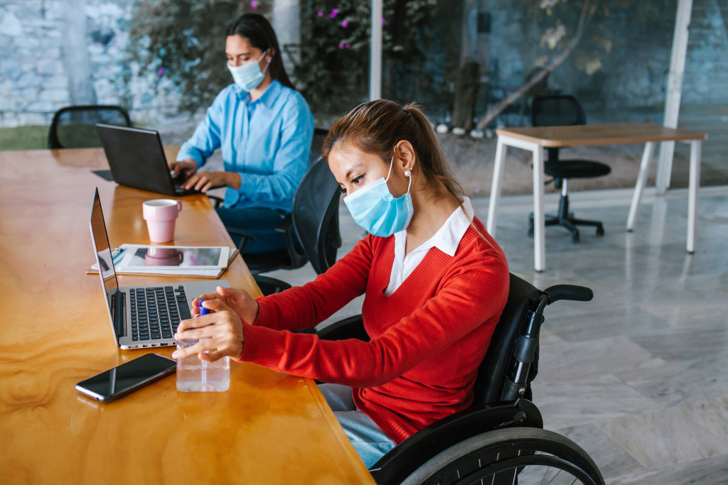 2 person with disability working while wearing a face mask