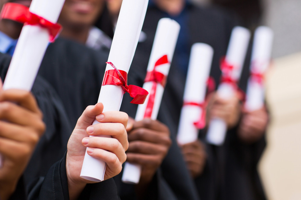 graduates holding their diplomats