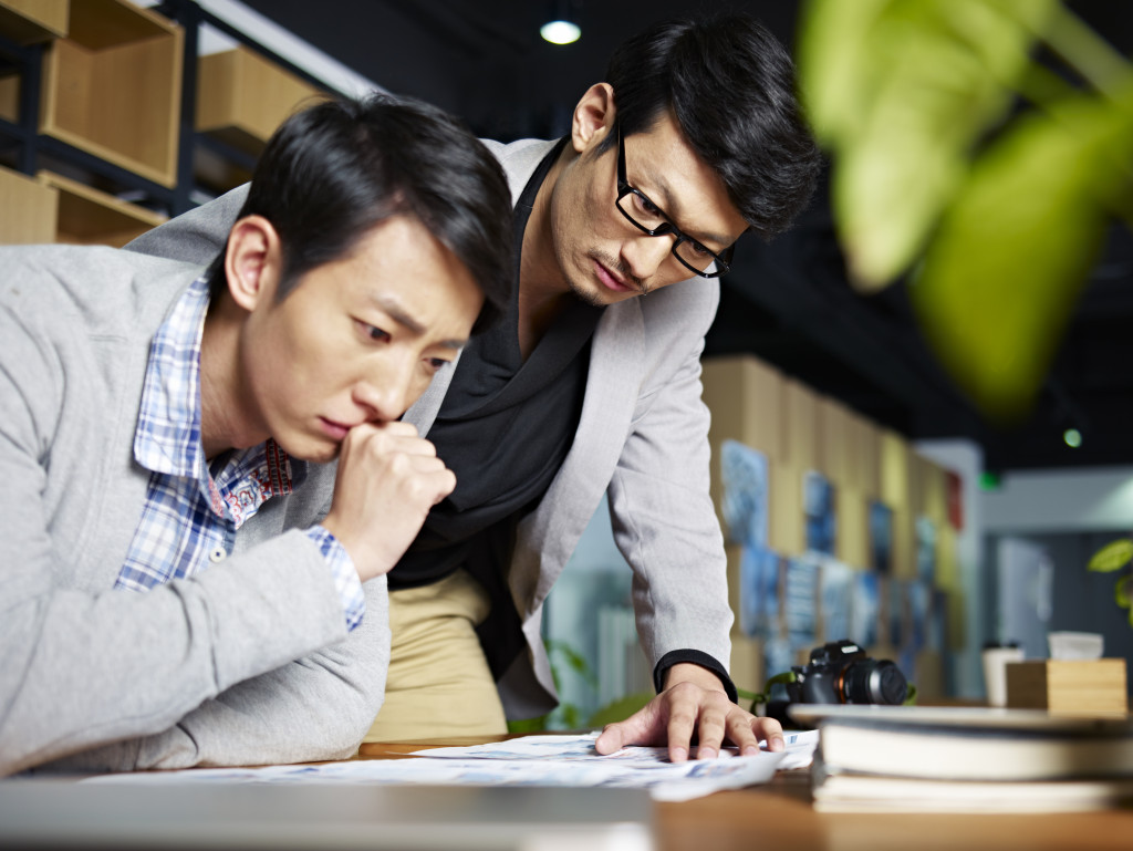 businessmen looking at the paper