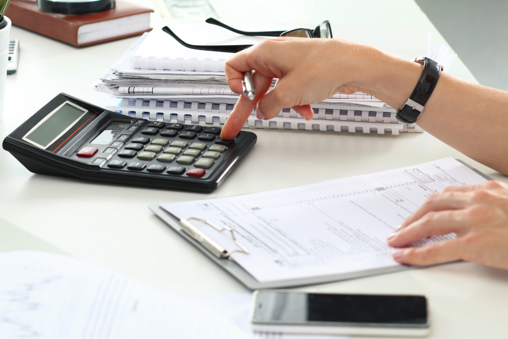 Close up of female accountant or banker making calculations. Savings, finances and economy concept