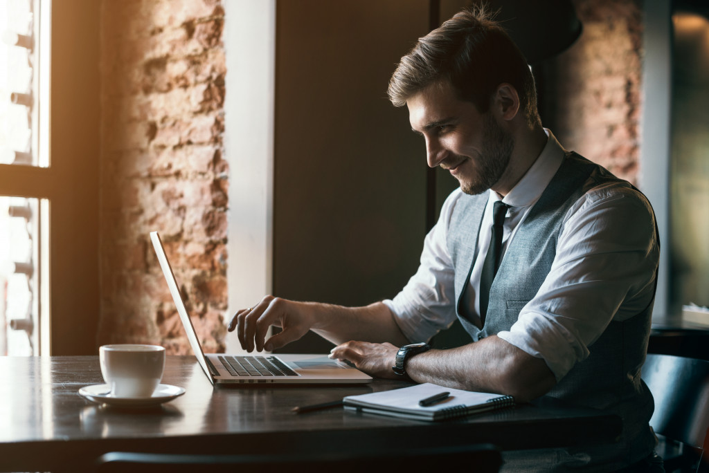 male smiling at his laptop