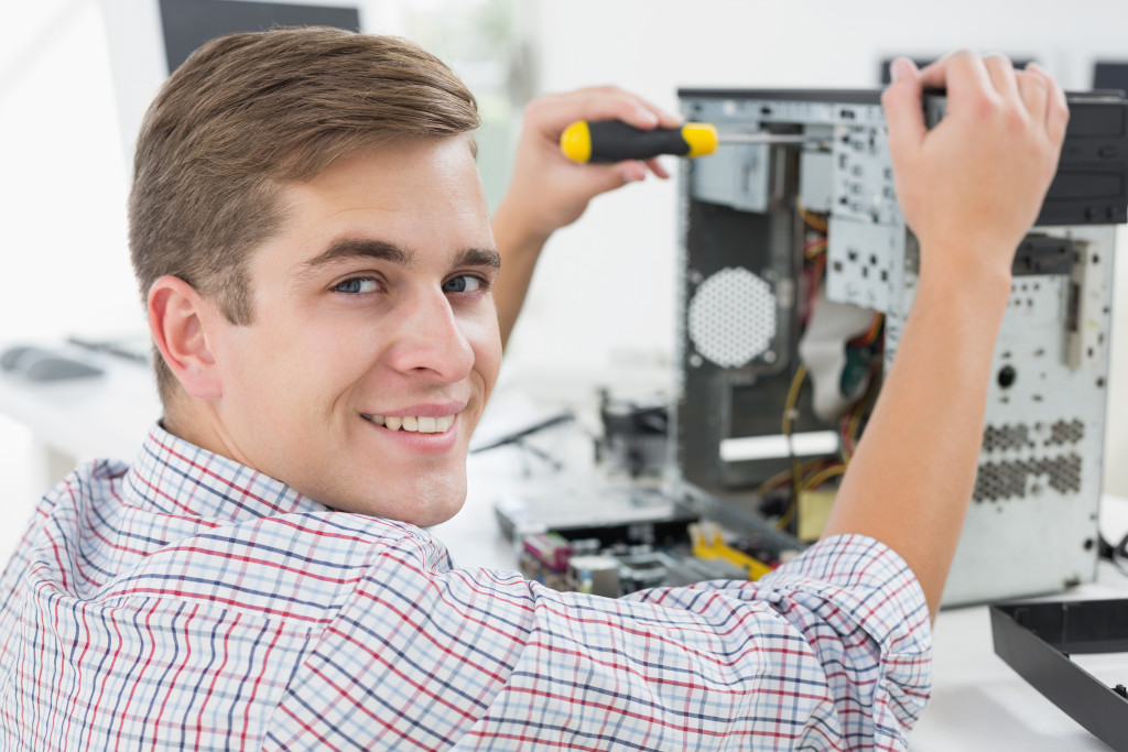 Smiling technician fixing a computer