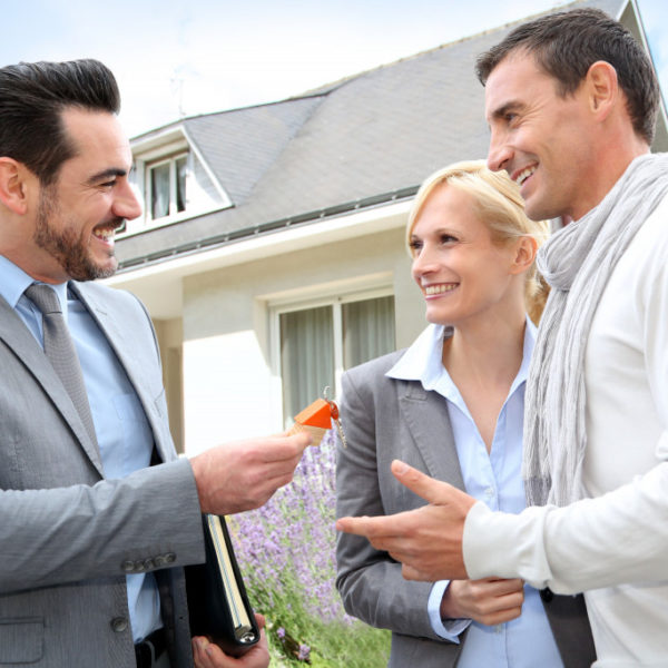 Salesman giving home keys to property owners
