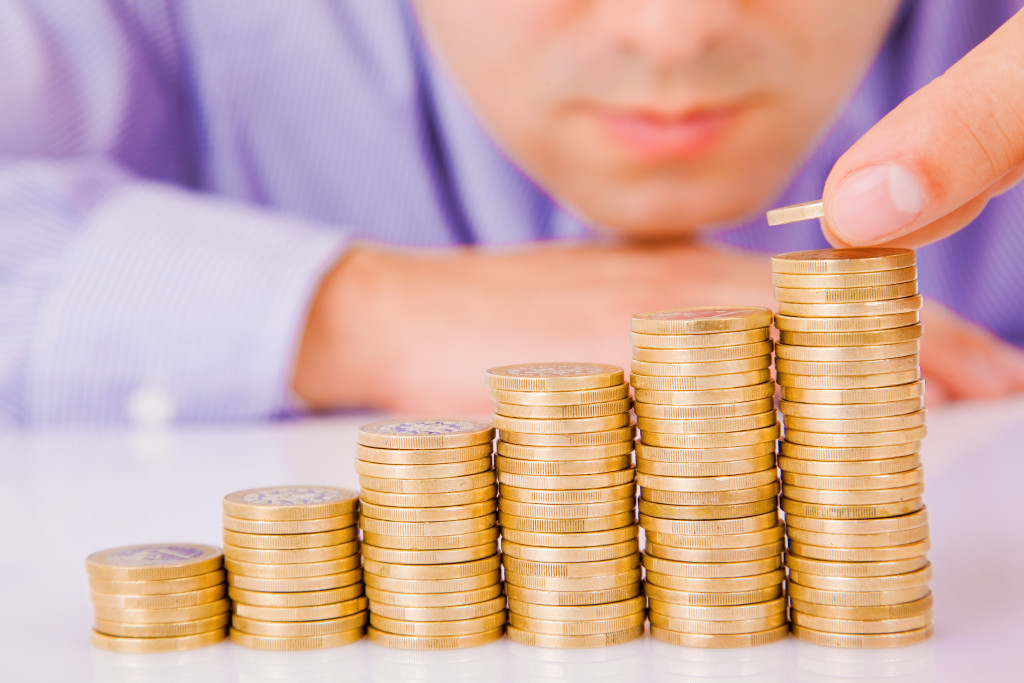 A businessman stacking coins in a rising order