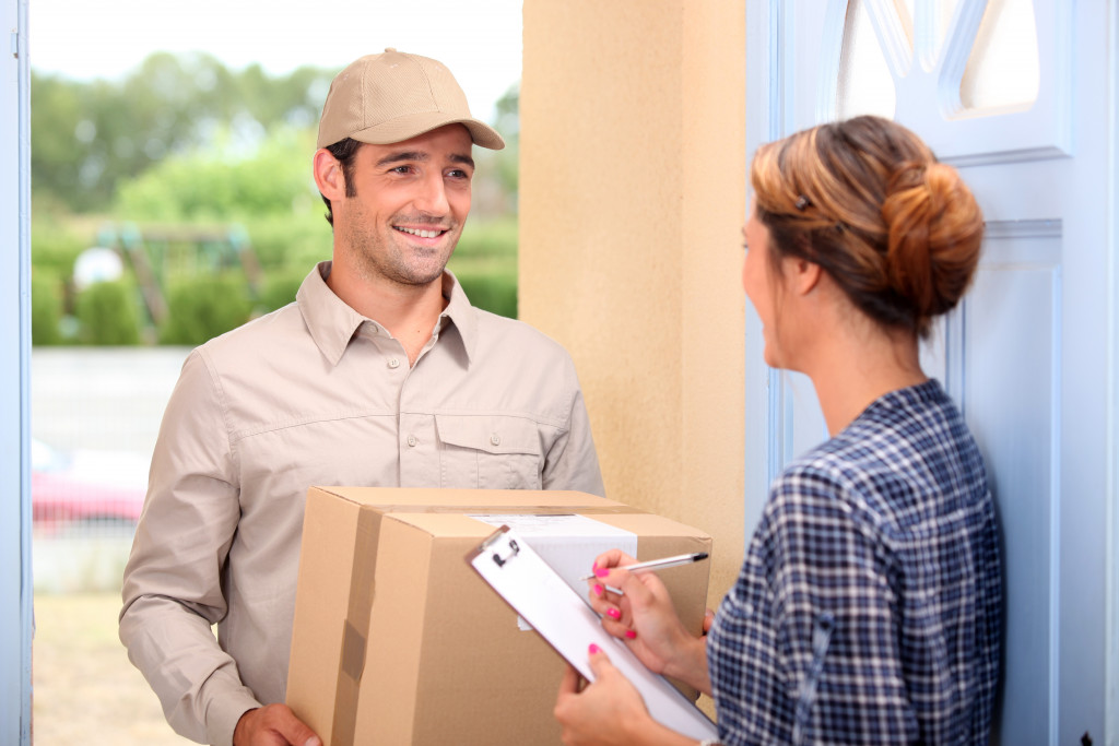 Man delivering parcel to a old woman 