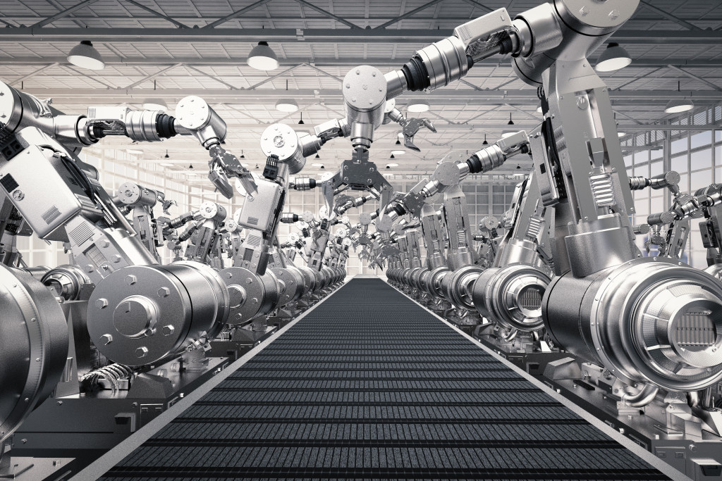 Robotic arms beside a conveyor belt