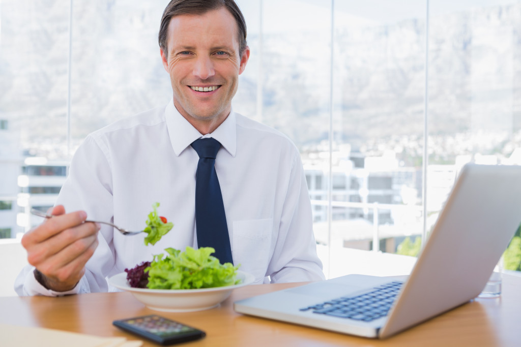 entrepreneur working while eating vegetable salad