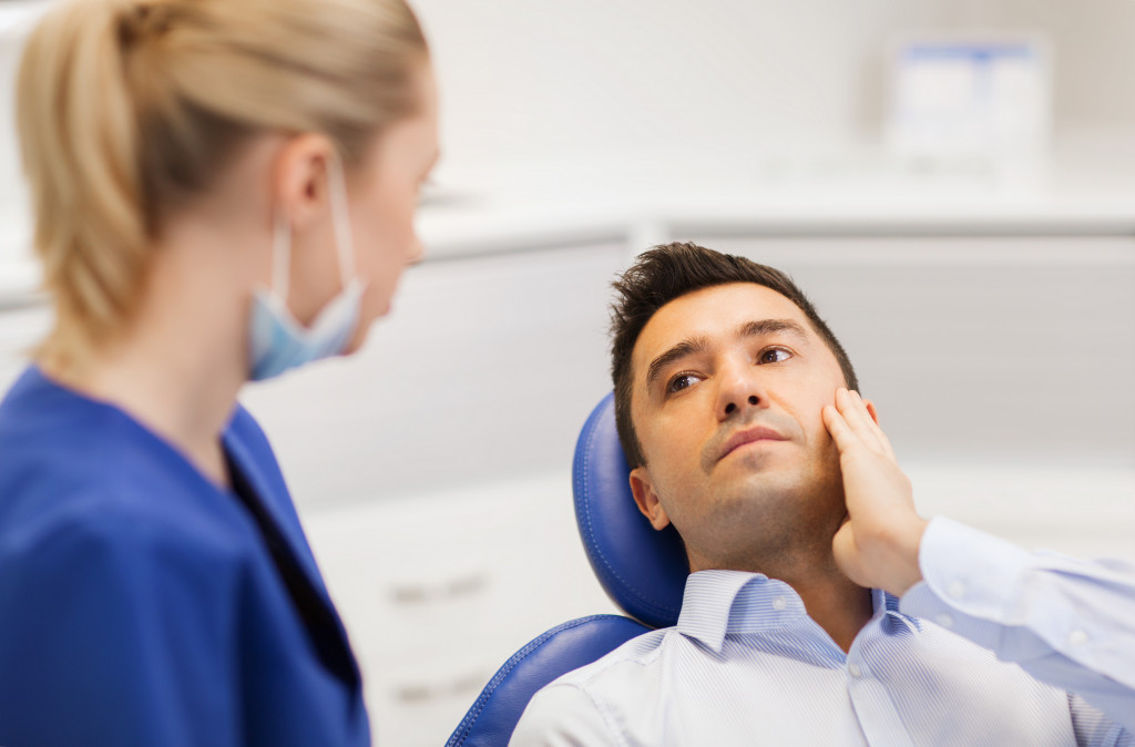 man on a dental checkup sitting 