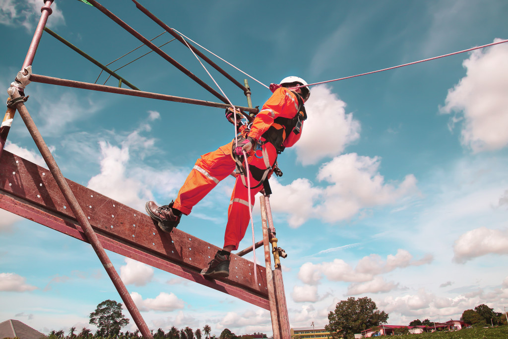 construction worker hoisted up by rigging materials in construction site