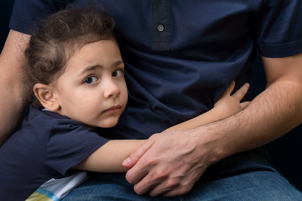 little child sad and hugging dad