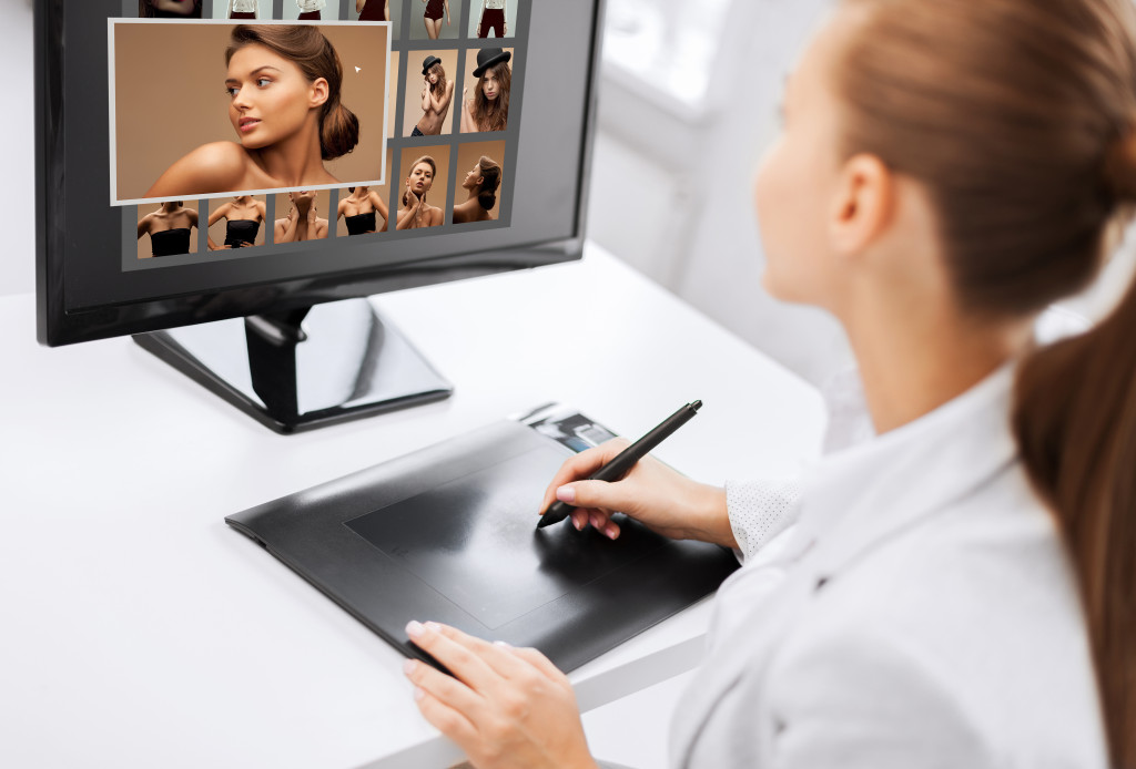 A woman editing a photo using a drawing pad