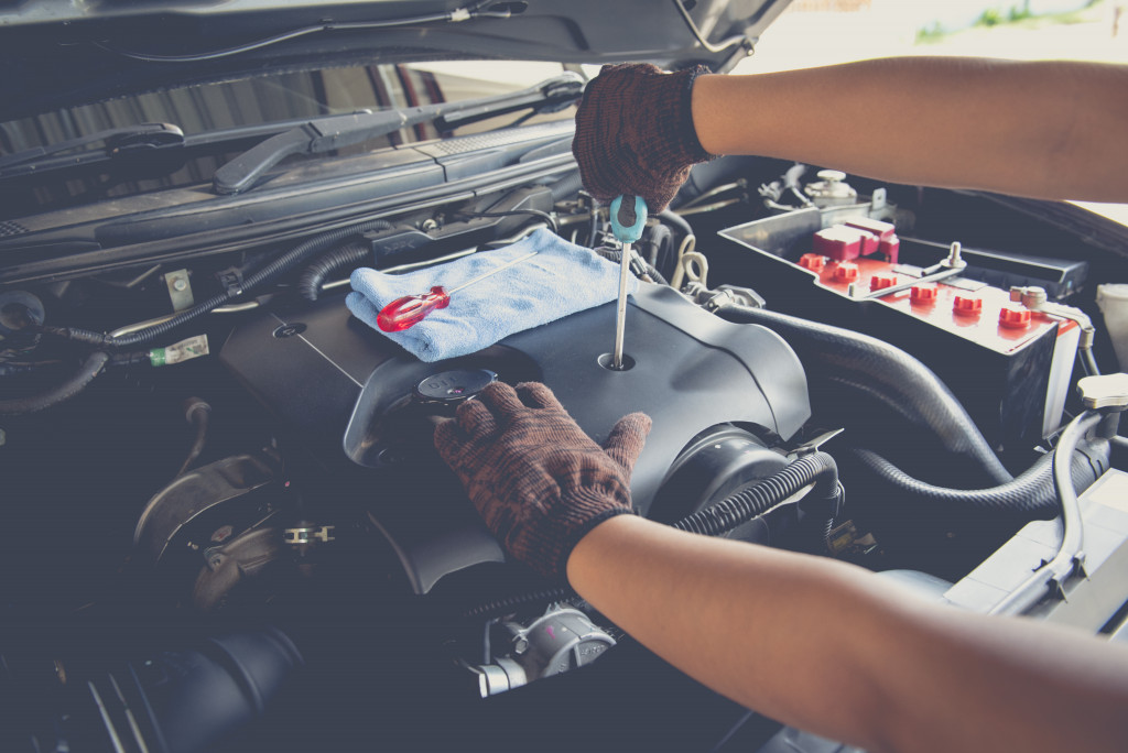 A mechanic using a screwdriver on a car's battery