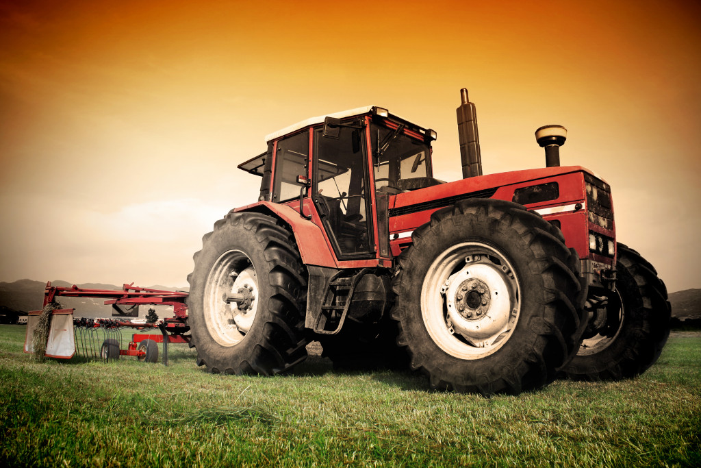 Farm tractor on a grass field of a farm.