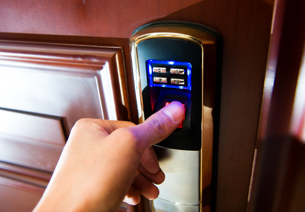 A person using their thumbprint to open a door