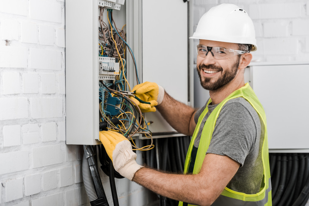 electrician checking electrical box in building