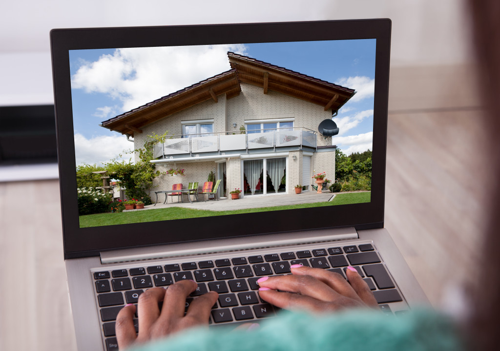 woman selecting new house on laptop at home